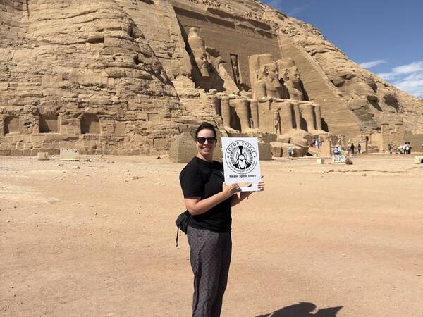 Luxor Spirit guest with the tour sign in front of Abu Simbel
